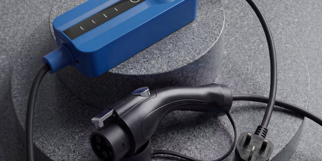 Voldt® Type 1 Portable Charger with UK three-pin plug on a dark stone surface